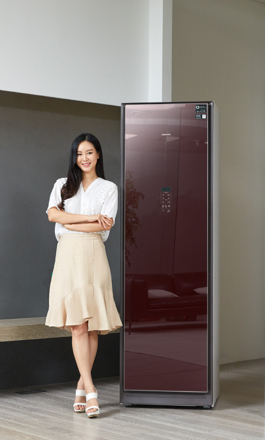 삼성전자가 의류청정기 '에어드레서'에 버건디 색상을 적용한 신모델을 15일 출시했다. 사진은 삼성전자 모델이 '버건디 미러'를 소개하는 모습.    삼성전자 제공